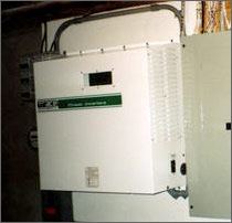 A photo of an inverter, which is basically a small, beige metal box with a display window on the front and vents on the side. 